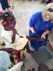 Debbie washing Miliene's feet at Women's Bible Study