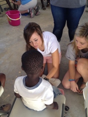 Jenny and Madison wash a child's feet who came with his mom to Women's Bible Study